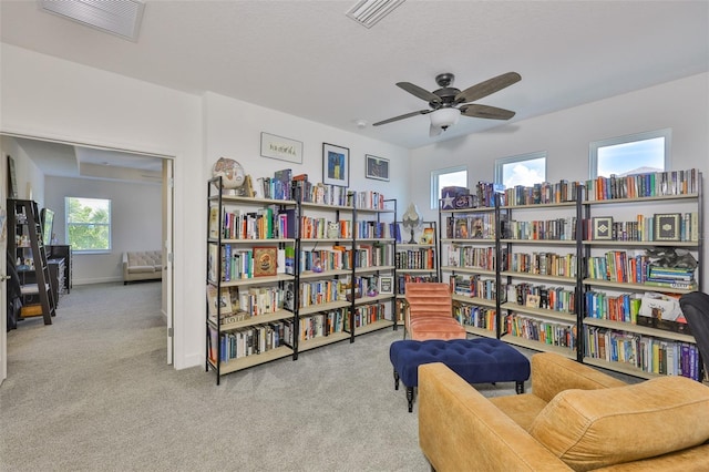 6215 Voyagers Pl, Apollo Beach, FL 33572 - living area with carpet flooring, a ceiling fan, and wall of books