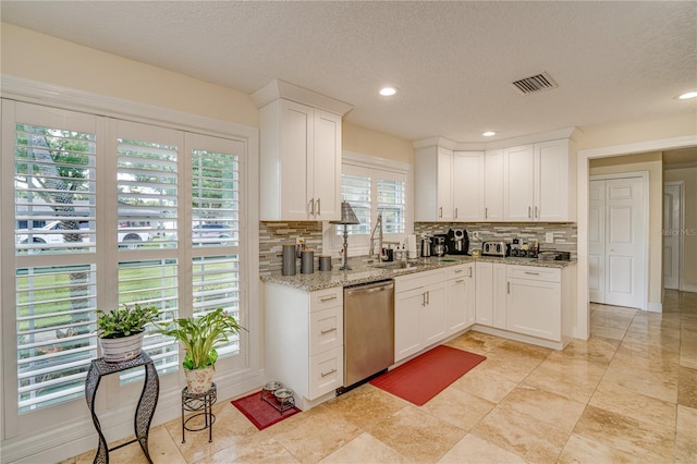 1954 Arvis Cir W, Clearwater, FL 33764 - kitchen with dishwasher, tasteful backsplash, white cabinetry, light stone counters, and a textured ceiling