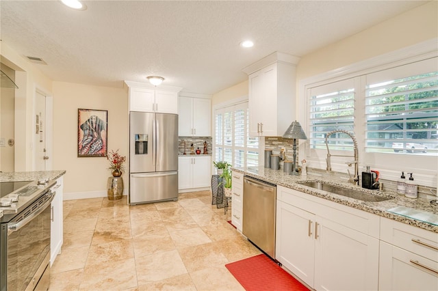 1954 Arvis Cir W, Clearwater, FL 33764 - kitchen with stainless steel appliances, recessed lighting, tasteful backsplash, white cabinetry, and light stone counters