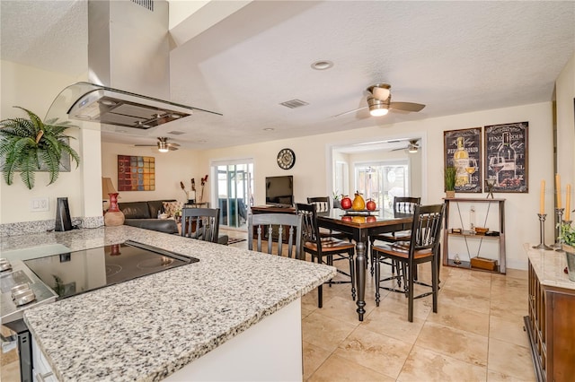 1954 Arvis Cir W, Clearwater, FL 33764 - kitchen featuring island exhaust hood, a ceiling fan, a peninsula, a textured ceiling, and light stone counters