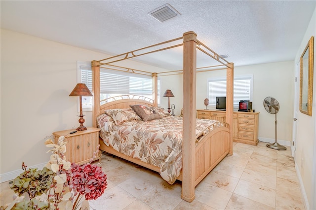 1954 Arvis Cir W, Clearwater, FL 33764 - bedroom with multiple windows, light tile patterned flooring, and a textured ceiling