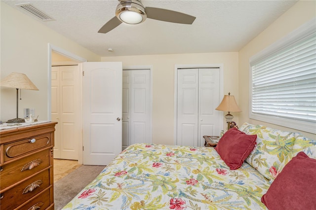 1954 Arvis Cir W, Clearwater, FL 33764 - bedroom with light carpet, multiple closets, a textured ceiling, and ceiling fan