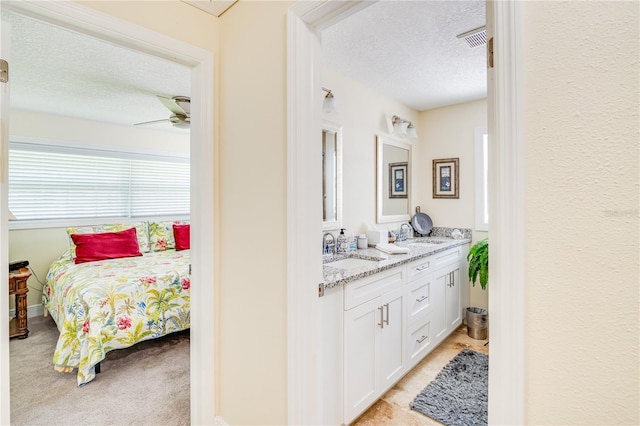 1954 Arvis Cir W, Clearwater, FL 33764 - bathroom with a textured ceiling, double vanity, and ceiling fan