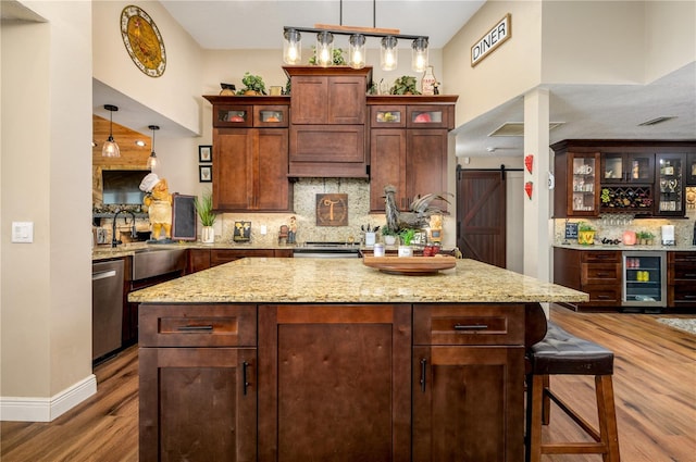 3539 Lake Padgett Dr, Land O Lakes, FL 34639 - kitchen with wood finished floors, wine cooler, backsplash, a barn door, and a center island