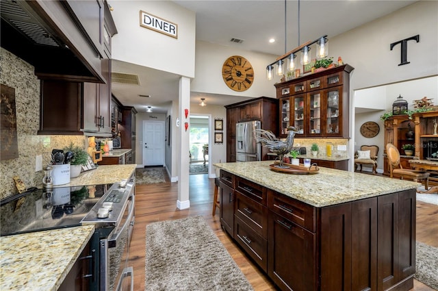 3539 Lake Padgett Dr, Land O Lakes, FL 34639 - kitchen featuring stainless steel appliances, extractor fan, tasteful backsplash, light wood finished floors, and a kitchen island