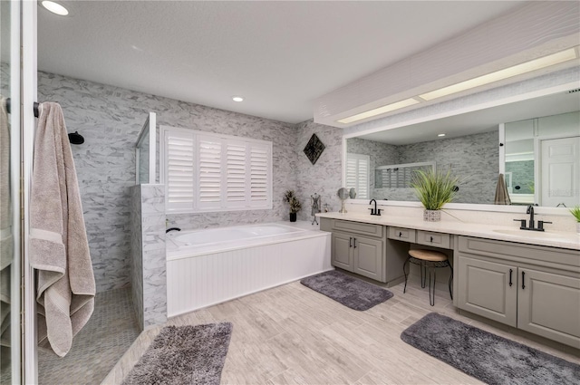 3539 Lake Padgett Dr, Land O Lakes, FL 34639 - full bath with double vanity, a garden tub, wallpapered walls, walk in shower, and wood finished floors