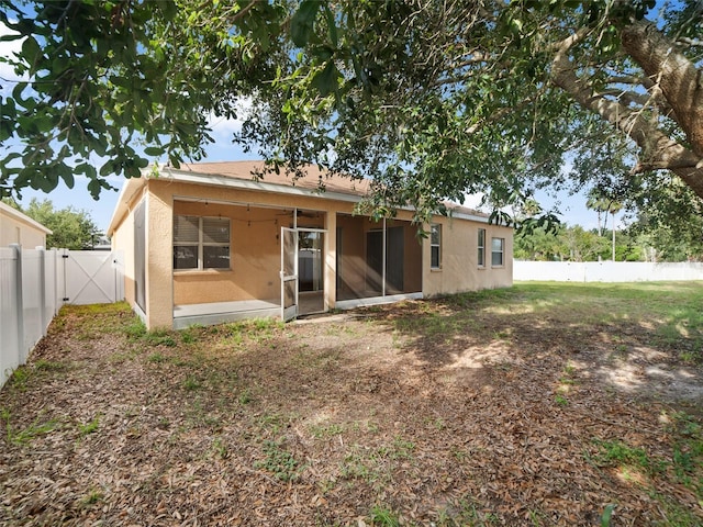 11212 Laurel Brook Ct, Riverview, FL 33569 - back of house featuring a fenced backyard, stucco siding, a gate, and a sunroom