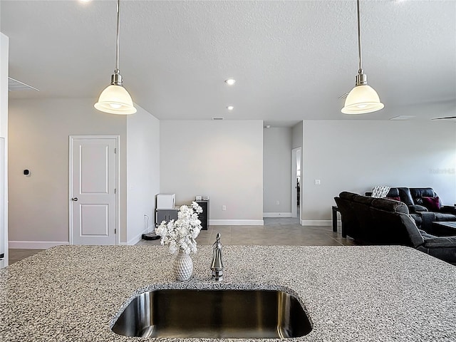 35428 Crescent Creek Dr, Zephyrhills, FL 33541 - kitchen with open floor plan, stone counters, hanging light fixtures, a textured ceiling, and recessed lighting