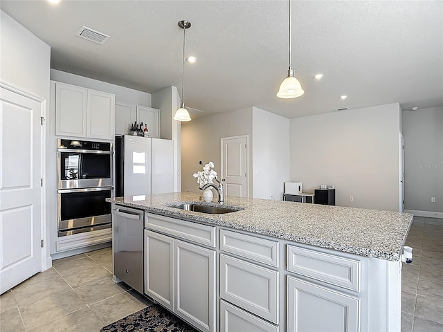 35428 Crescent Creek Dr, Zephyrhills, FL 33541 - kitchen with stainless steel appliances, an island with sink, light stone countertops, recessed lighting, and pendant lighting