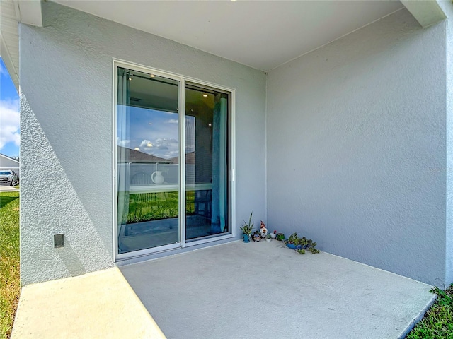 35428 Crescent Creek Dr, Zephyrhills, FL 33541 - doorway to property with stucco siding and a patio area