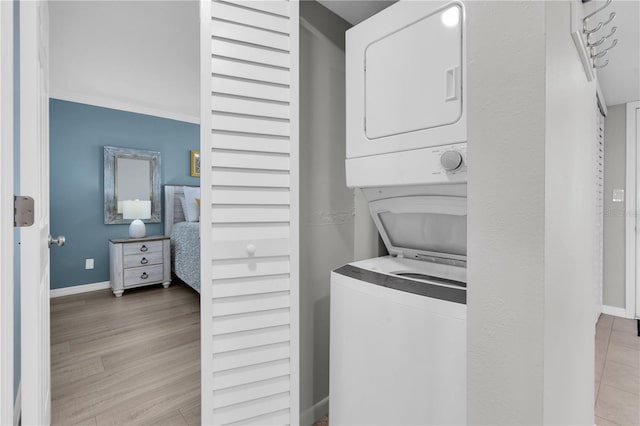 9495 Blind Pass Rd Unit 1103, St Pete Beach, FL 33706 - laundry area featuring estacked washer and dryer and wood finished floors
