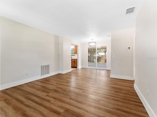 1024 San Marco Dr, Largo, FL 33770 - unfurnished living room with a chandelier and light wood-style flooring