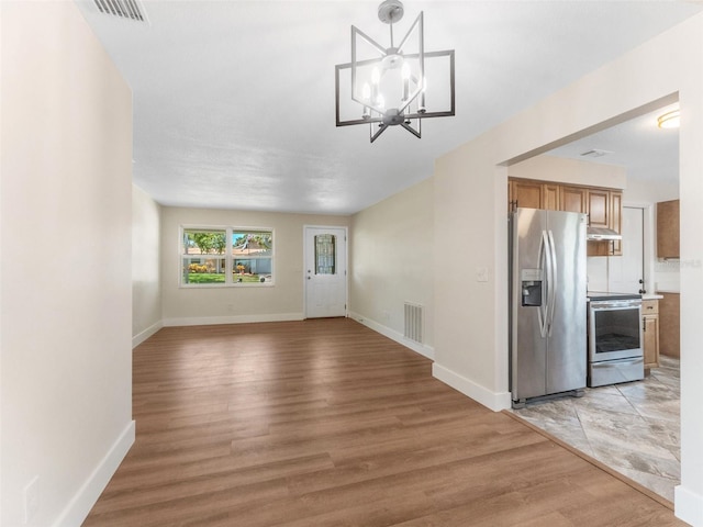 1024 San Marco Dr, Largo, FL 33770 - unfurnished living room with a chandelier and light wood-style floors