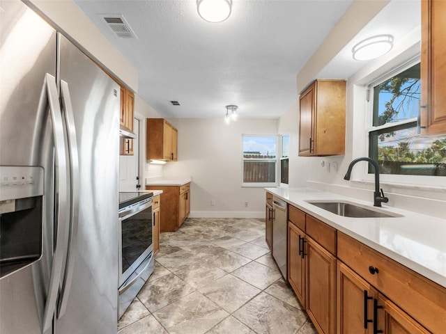 1024 San Marco Dr, Largo, FL 33770 - kitchen with stainless steel appliances, brown cabinetry, and healthy amount of natural light