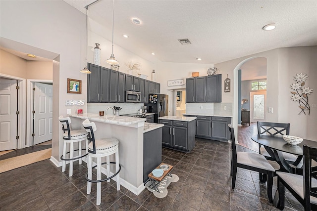 3509 Williston Loop, Land O Lakes, FL 34639 - kitchen with stainless steel microwave, arched walkways, black refrigerator with ice dispenser, a textured ceiling, and a peninsula