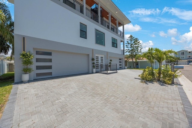 18077 3rd St E, Redington Shores, FL 33708 - view of front of home with a garage, decorative driveway, and stucco siding