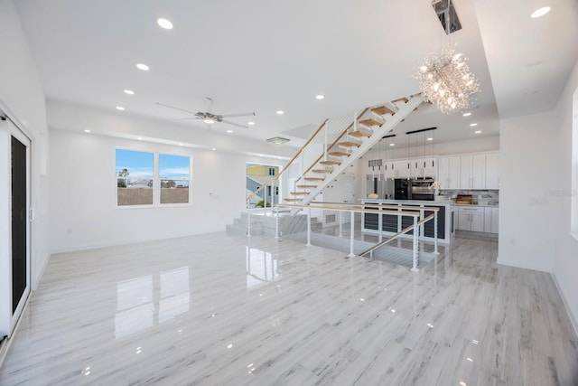 18077 3rd St E, Redington Shores, FL 33708 - unfurnished living room with recessed lighting, stairway, a ceiling fan, a chandelier, and light wood finished floors