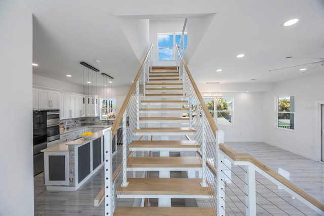 18077 3rd St E, Redington Shores, FL 33708 - stairs featuring healthy amount of natural light, wood finished floors, and recessed lighting