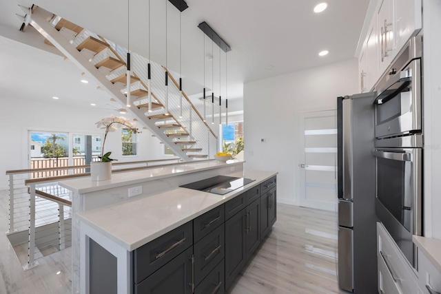 18077 3rd St E, Redington Shores, FL 33708 - kitchen featuring stainless steel appliances, white cabinets, a center island, decorative light fixtures, and recessed lighting