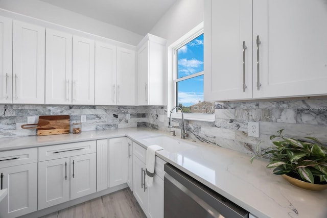 18077 3rd St E, Redington Shores, FL 33708 - kitchen featuring dishwasher, white cabinets, decorative backsplash, light stone counters, and light wood-style floors