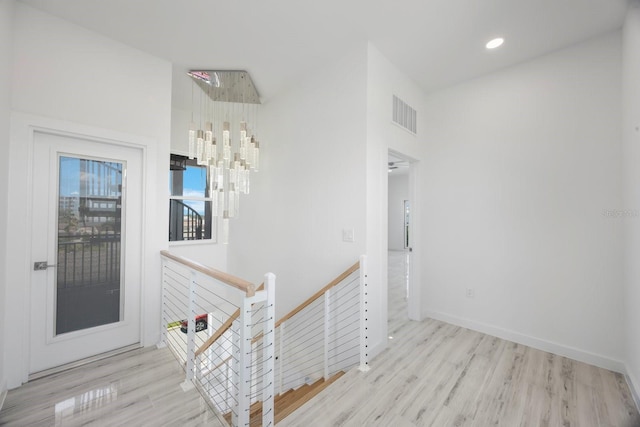 18077 3rd St E, Redington Shores, FL 33708 - staircase with wood finished floors, a chandelier, and recessed lighting