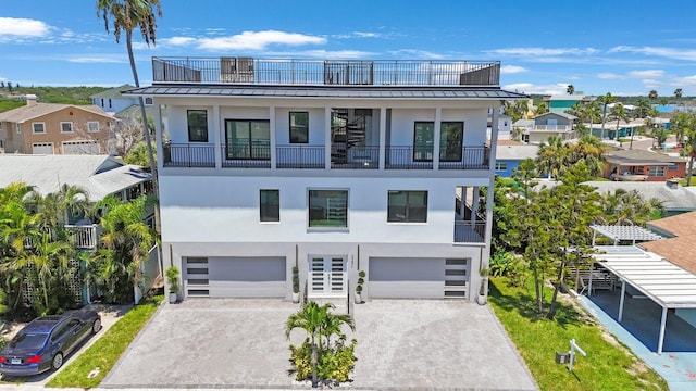 18077 3rd St E, Redington Shores, FL 33708 - view of front of property featuring a balcony, stucco siding, a standing seam roof, and a metal roof