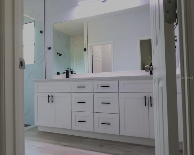 2522 W Castle Rd, Dunnellon, FL 34434 - bathroom featuring a marble finish shower, double vanity, and wood finished floors