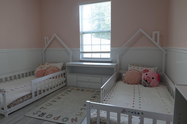 2522 W Castle Rd, Dunnellon, FL 34434 - bedroom featuring a crib and a wainscoted wall