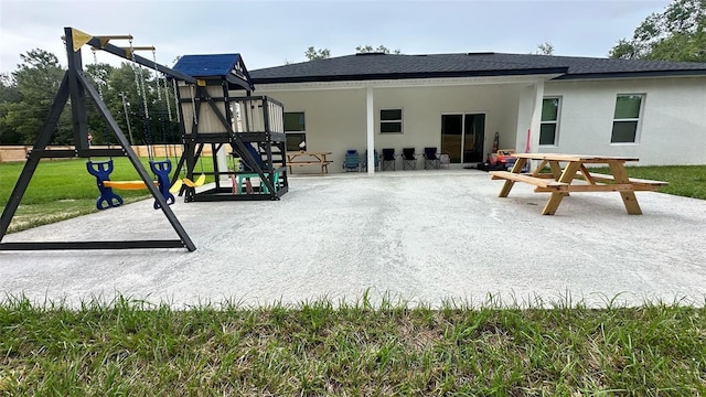2522 W Castle Rd, Dunnellon, FL 34434 - back of property with a playground, stucco siding, and roof with shingles