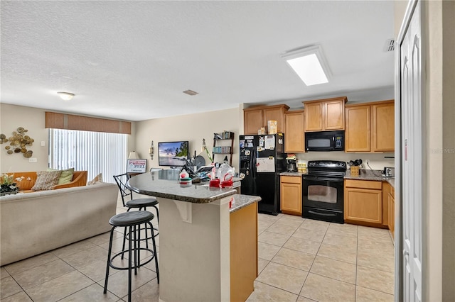 1037 Cypress Pointe Blvd, Davenport, FL 33896 - kitchen featuring black appliances, open floor plan, a kitchen bar, light tile patterned floors, and a kitchen island