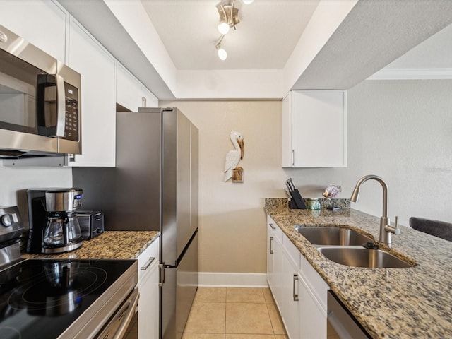 10265 Gulf Blvd Unit A107, Saint Petersburg, FL 33706 - kitchen with stainless steel appliances, white cabinets, light tile patterned floors, and light stone countertops