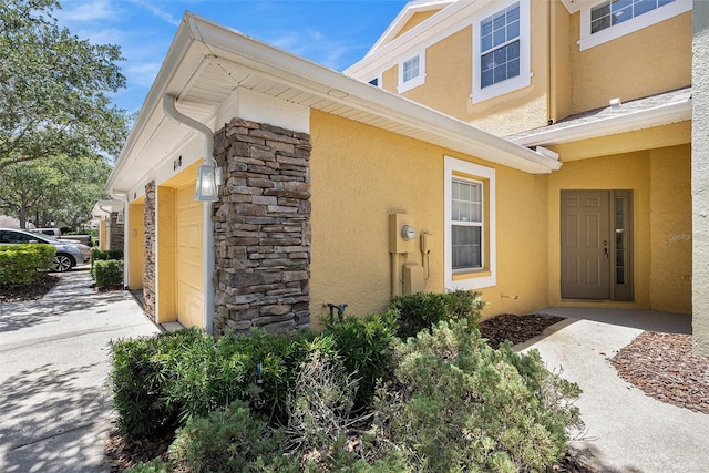 8118 Stone Path Way, Tampa, FL 33647 - entrance to property featuring stone siding, stucco siding, and concrete driveway