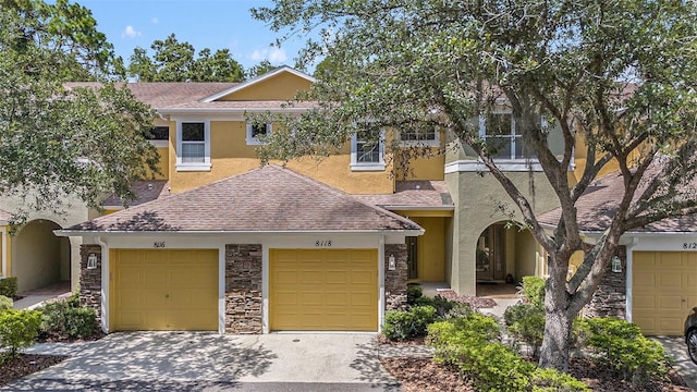 8118 Stone Path Way, Tampa, FL 33647 - view of front of house with stucco siding, stone siding, roof with shingles, and an attached garage