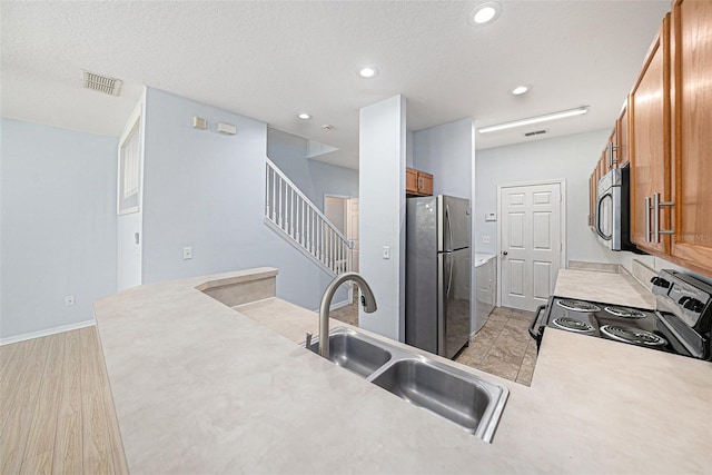8118 Stone Path Way, Tampa, FL 33647 - kitchen featuring appliances with stainless steel finishes, brown cabinets, light countertops, light wood-type flooring, and recessed lighting