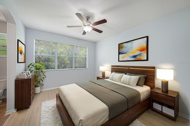8118 Stone Path Way, Tampa, FL 33647 - bedroom with arched walkways, light wood-style flooring, and a ceiling fan