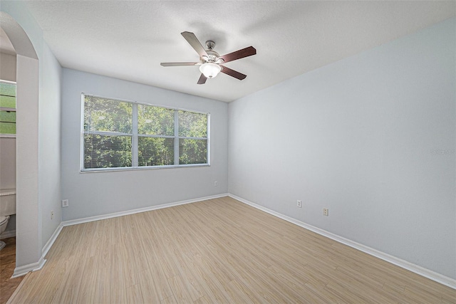 8118 Stone Path Way, Tampa, FL 33647 - unfurnished room featuring arched walkways, light wood-type flooring, and a ceiling fan