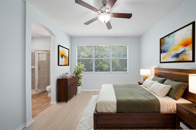 8118 Stone Path Way, Tampa, FL 33647 - bedroom with arched walkways, ensuite bath, a ceiling fan, and a textured ceiling