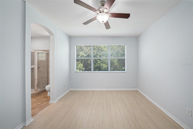 8118 Stone Path Way, Tampa, FL 33647 - unfurnished room featuring arched walkways, light wood-style flooring, and ceiling fan