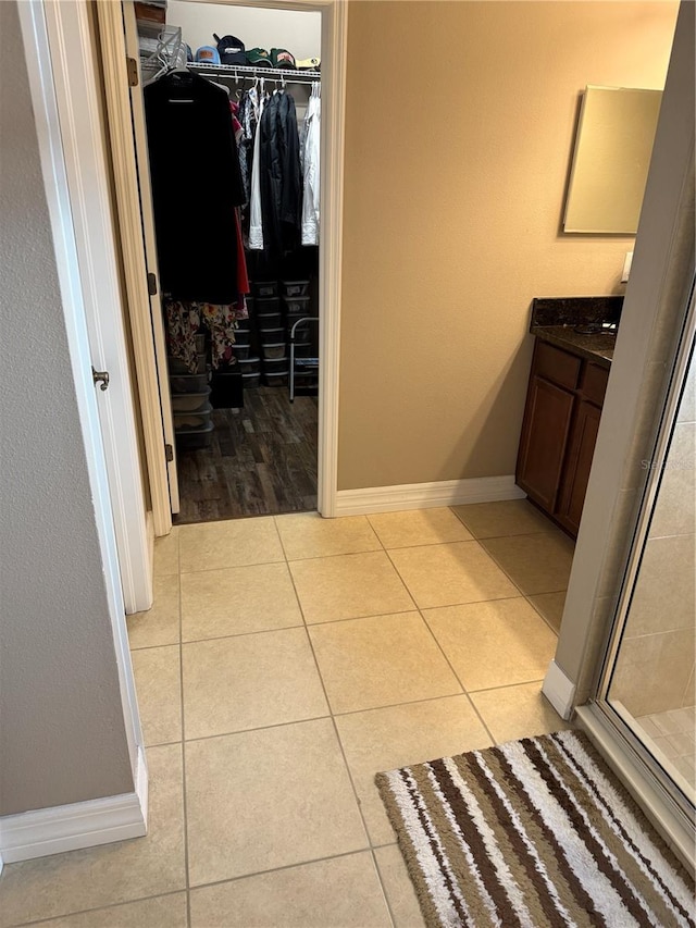 4432 Vermillion Sky Dr, Wesley Chapel, FL 33544 - bathroom featuring a spacious closet, tile patterned flooring, vanity, and a stall shower