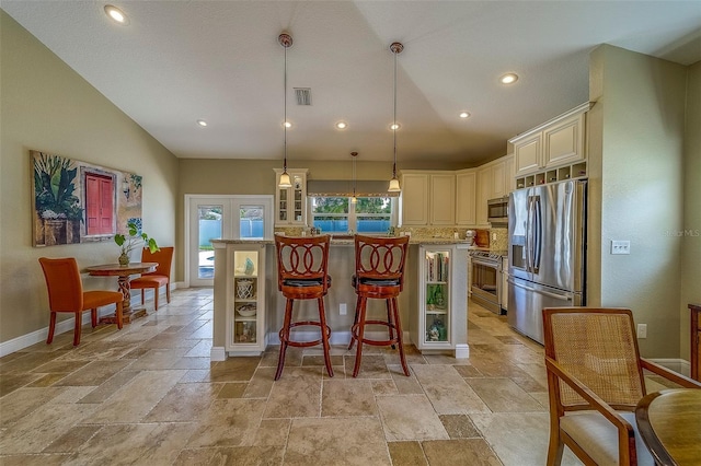 13425 San Rafael Dr, Largo, FL 33774 - kitchen featuring appliances with stainless steel finishes, stone tile floors, recessed lighting, cream cabinetry, and a kitchen island
