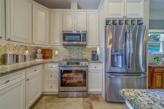 13425 San Rafael Dr, Largo, FL 33774 - kitchen with appliances with stainless steel finishes, backsplash, light stone counters, white cabinets, and light stone finish floors