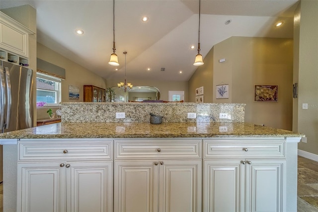 13425 San Rafael Dr, Largo, FL 33774 - kitchen featuring freestanding refrigerator, a chandelier, vaulted ceiling, light stone counters, and white cabinetry