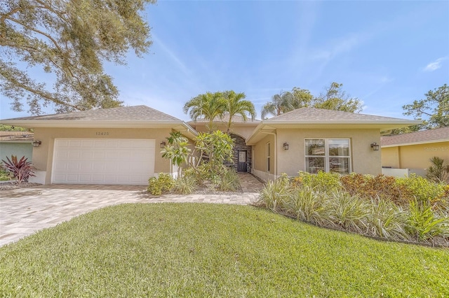 13425 San Rafael Dr, Largo, FL 33774 - ranch-style house featuring stucco siding, an attached garage, a front yard, and driveway