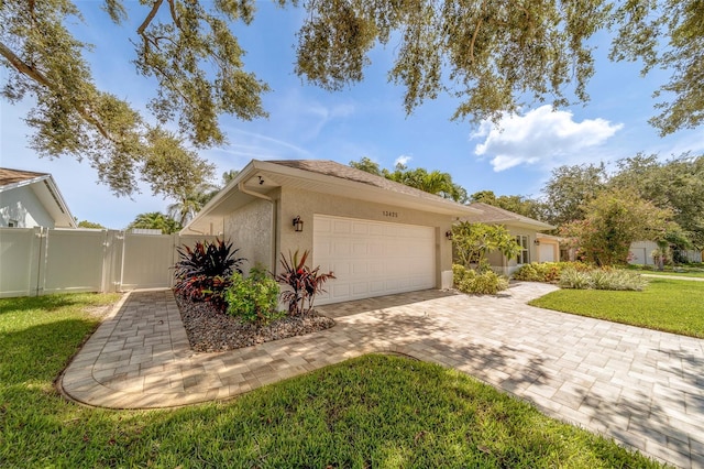 13425 San Rafael Dr, Largo, FL 33774 - view of home's exterior featuring stucco siding, a garage, decorative driveway, and a gate