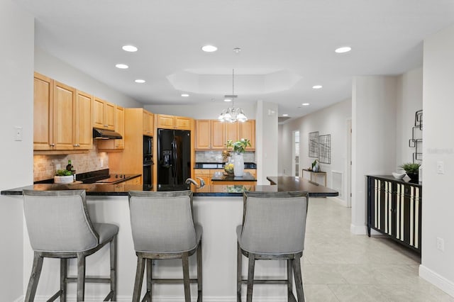 17735 Gulf Blvd Unit 502, Redington Shores, FL 33708 - kitchen featuring black appliances, recessed lighting, tasteful backsplash, a peninsula, and under cabinet range hood