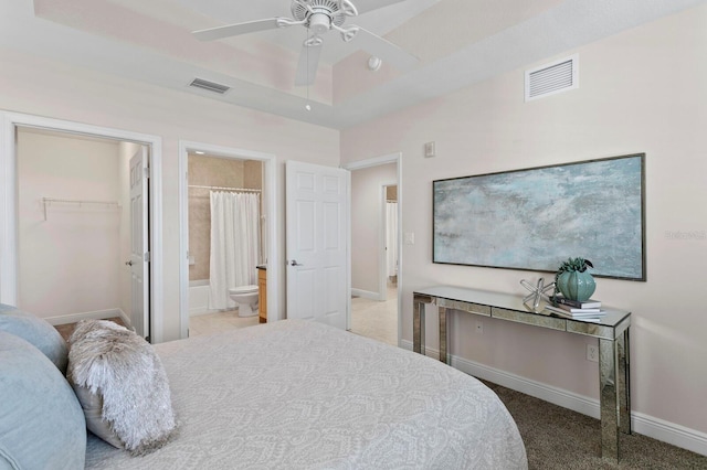 17735 Gulf Blvd Unit 502, Redington Shores, FL 33708 - bedroom with a walk in closet, carpet floors, ensuite bathroom, a ceiling fan, and a tray ceiling