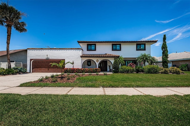 10866 Harborside Dr, Largo, FL 33773 - mediterranean / spanish-style house with an attached garage, stucco siding, concrete driveway, and a front yard