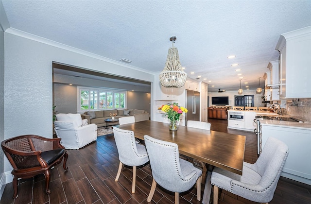 10866 Harborside Dr, Largo, FL 33773 - dining room with a chandelier, dark wood-style flooring, ornamental molding, recessed lighting, and a textured wall