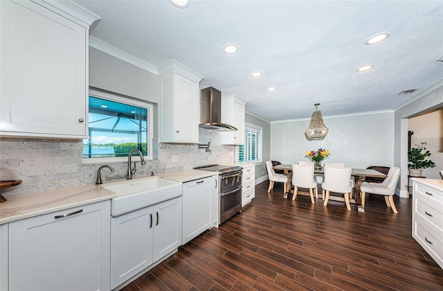 10866 Harborside Dr, Largo, FL 33773 - kitchen with ornamental molding, range with two ovens, wall chimney range hood, recessed lighting, and white cabinetry