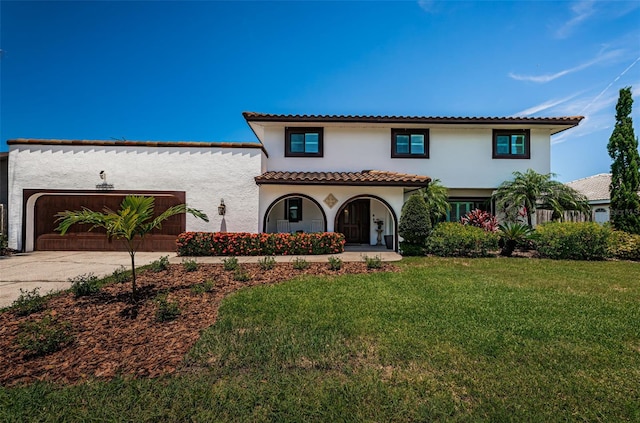 10866 Harborside Dr, Largo, FL 33773 - mediterranean / spanish home with stucco siding, concrete driveway, a front lawn, a garage, and a tile roof